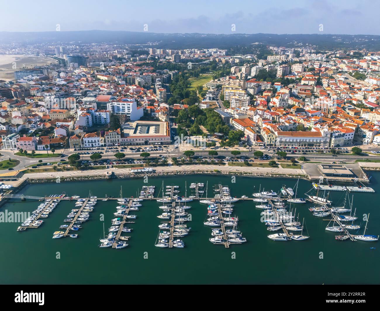 Aerial view of a coastal city with a marina filled with boats ...