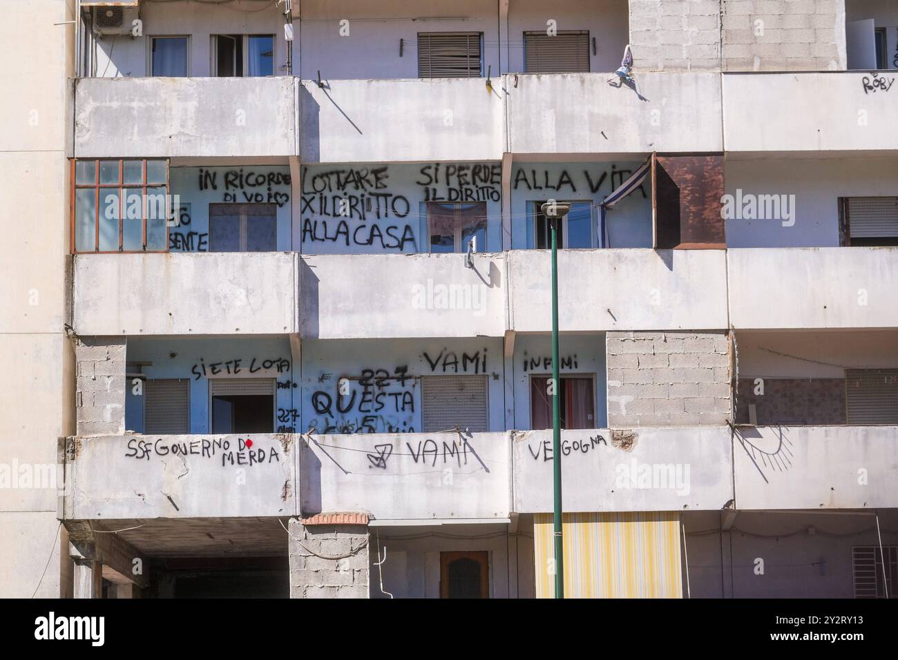 News - Vele of Scampia, Mayor Manfredi orders urgent eviction An inscription on the balcony of the sails reads Fight for the right to housing, you lose the right to life .The mayor of Naples Gaetano Manfredi has signed two ordinances for the ad horas eviction of the Vela Gialla and Vela Rossa in Scampia, the two buildings scheduled for demolition. The orders were signed for safety reasons and because of the risks threatening public and private safety . The two buildings are owned by the City of Naples and currently occupied, located in the Scampia district in Via della Resistenza, block C - Ve Stock Photo