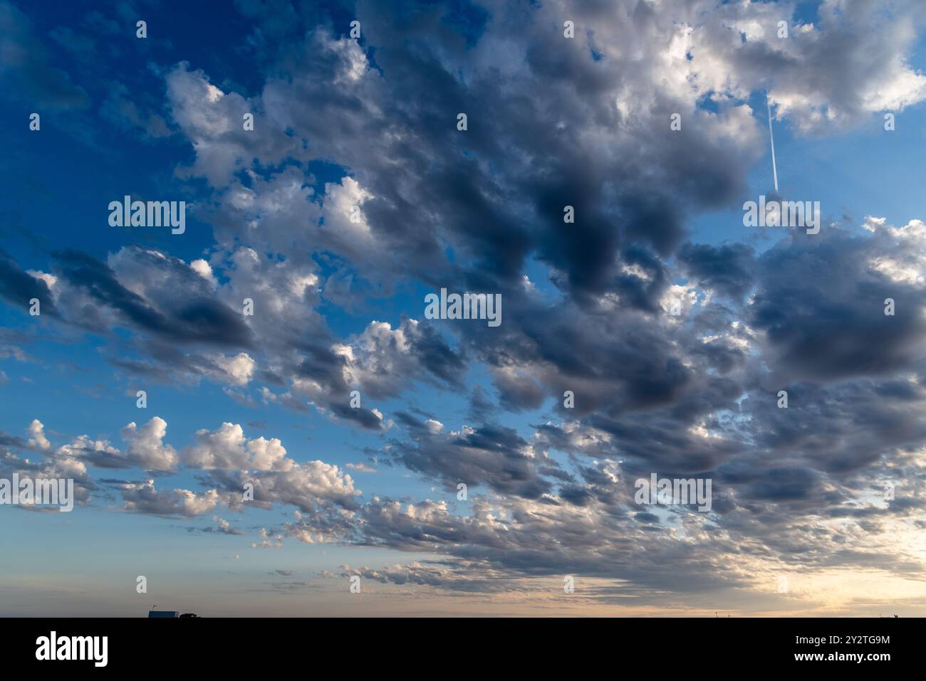 Beautiful white puffy clouds against blue sky during dramatic sunset. Stock Photo