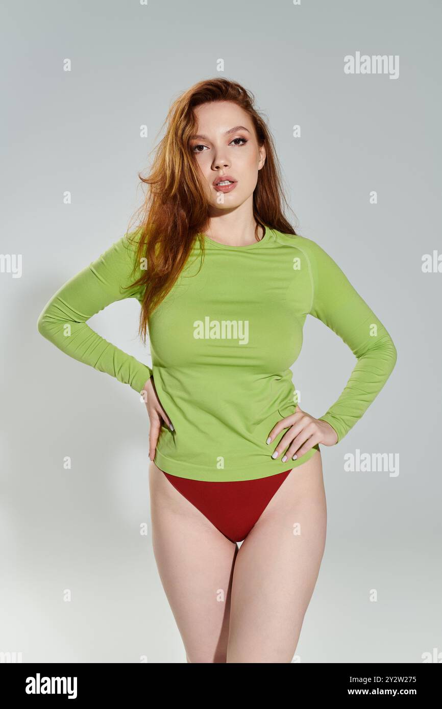 A striking red haired woman showcases her fashionable style in bold colors. Stock Photo