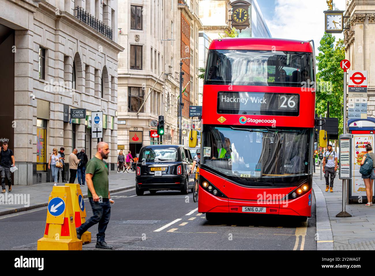 Bus Approach A No 26 red London double decker bus approaches a bus stop on Poultry ...