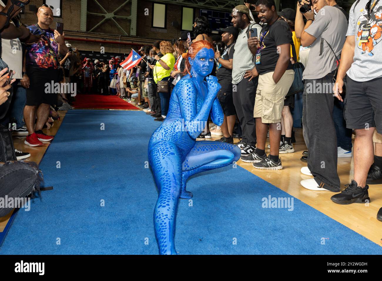 A person in blue body paint costume as mystique from x men posing on a ...