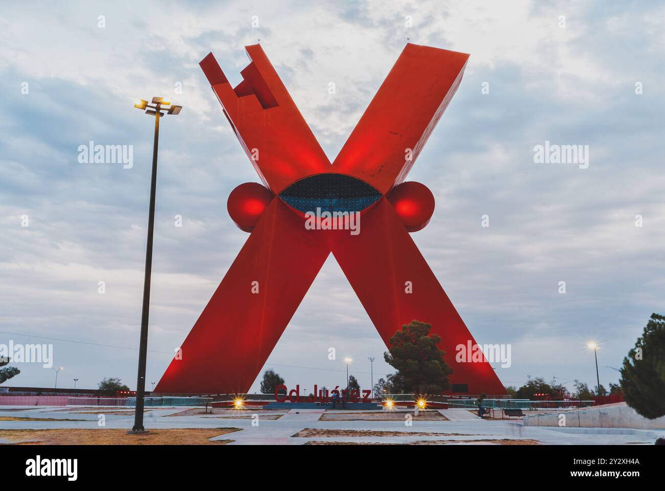 The large red X monument in Ciudad Juarez, Mexico, with a cloudy sky background. Stock Photo