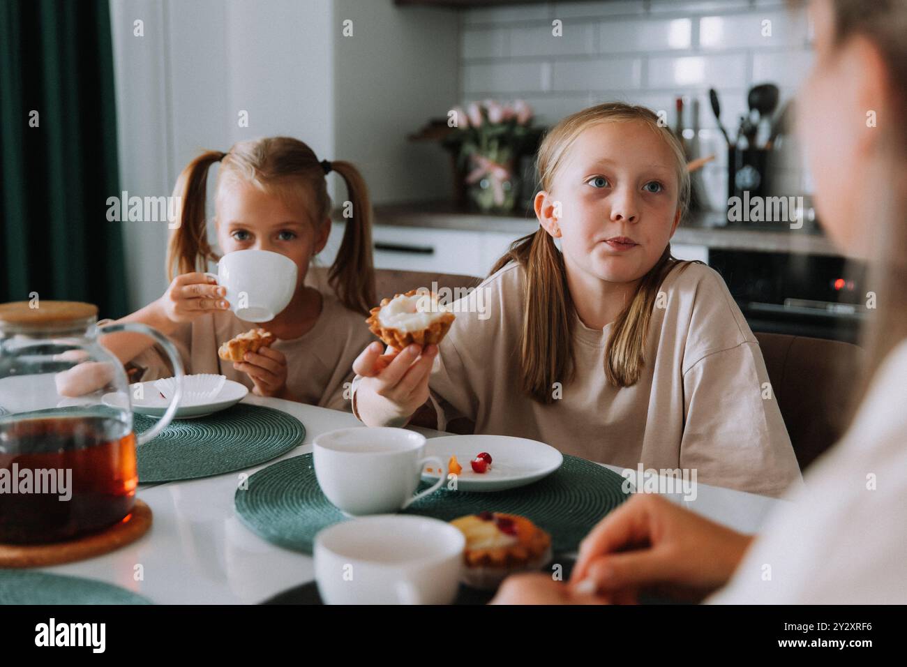 Breakfast Little Two little girls have breakfast with their mother in the kitchen Stock ...