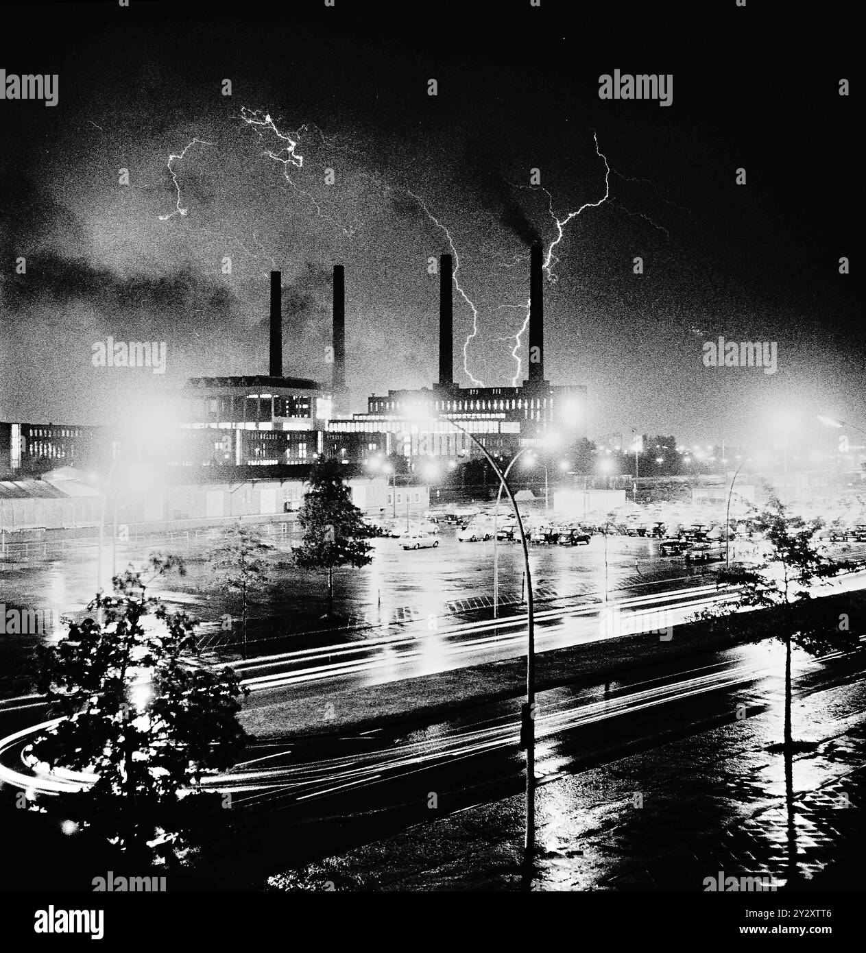 RECORD DATE NOT STATED Gewitter über das Volkswagenwerk in Wolfsburg - wie ihier in der Oelkrise 1973. Im Foto: das alte VW Kraftwerk mit den 4 Schornsteinen und vorn die Heinrich Nordhoff Str. mit VW Parkplatz für Mitarbeiter *** Thunderstorm over the Volkswagen plant in Wolfsburg like here in the oil crisis 1973 In the photo the old VW power plant with the 4 chimneys and in front the Heinrich Nordhoff Str with VW parking lot for employees Stock Photo