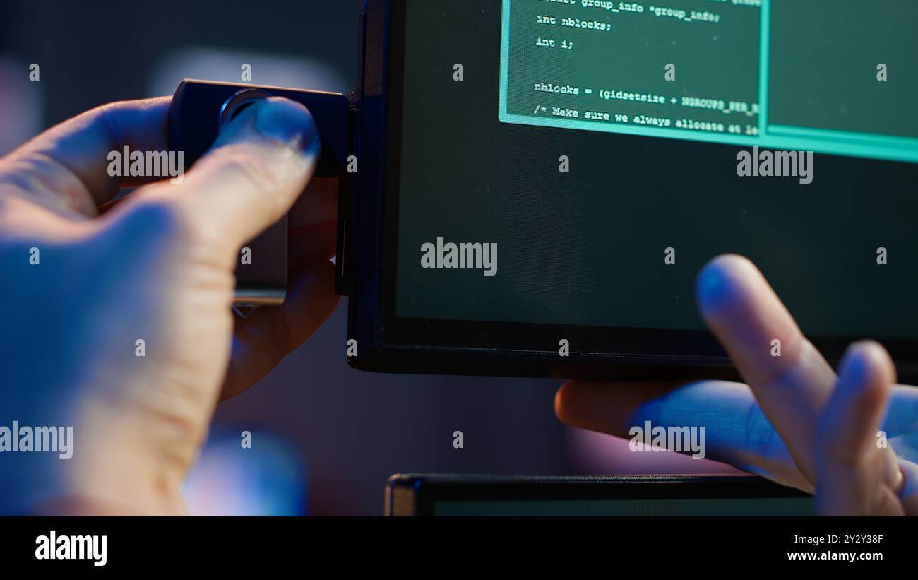 Hacker inserting USB in computer after managing to steal sensitive data, close up. Scammer uploading storage drive into PC after obtaining sensitive information from users using malware, camera A Stock Photo