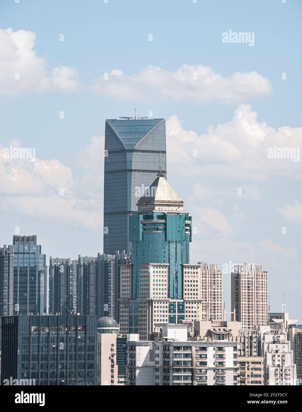 A cityscape view of modern skyscrapers under a blue sky with clouds in Shanghai, China Stock Photo