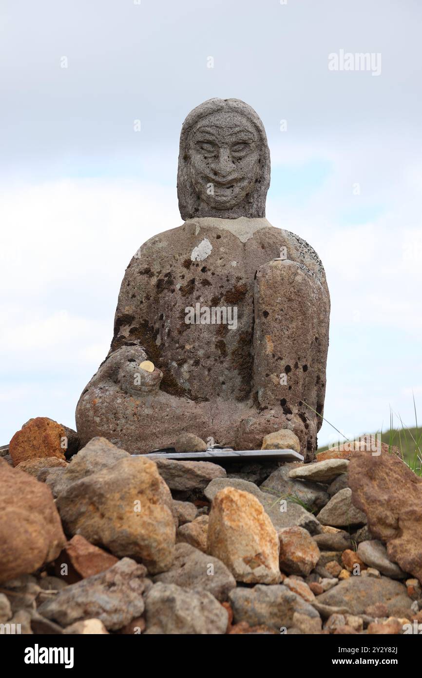 Suporting Statue Rocks An ancient stone statue of a seated figure surrounded by rocks under a ...