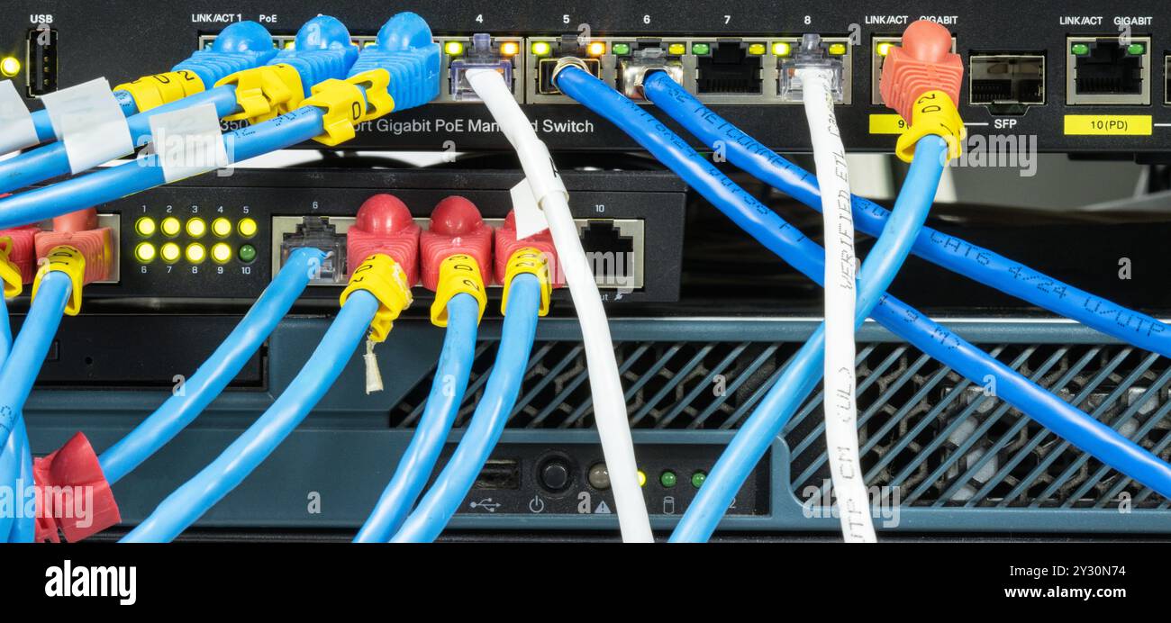 Network hub with LAN cable connected to patch cables connected to internet data center Stock Photo