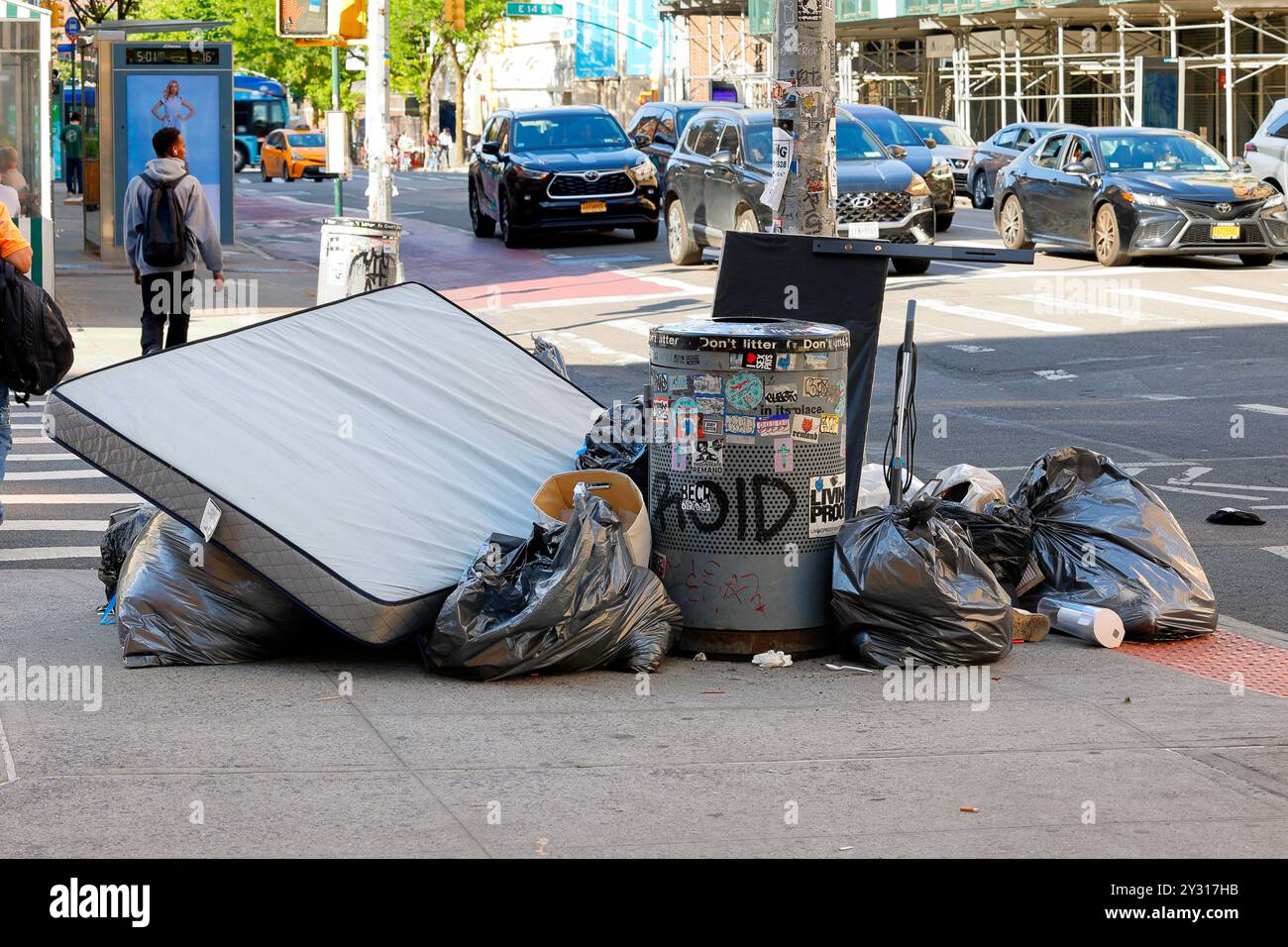 Dumping of household trash at a corner litter basket in New York City Stock Photo