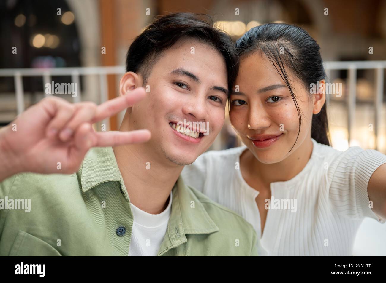 A lovely, happy young Asian couple is taking a selfie together while on ...