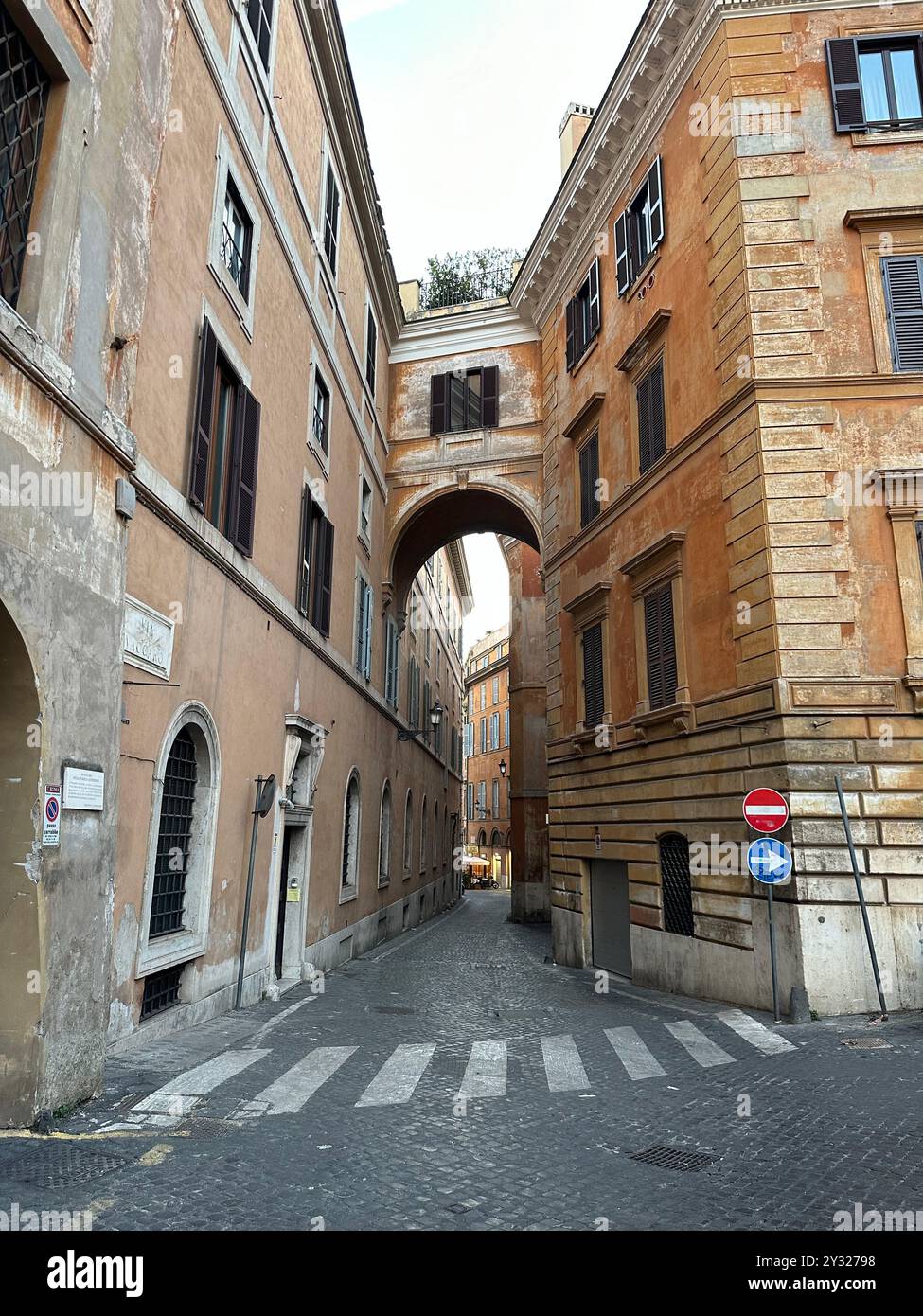 A cobblestone street in Rome, Italy, flanked by historic buildings with ...