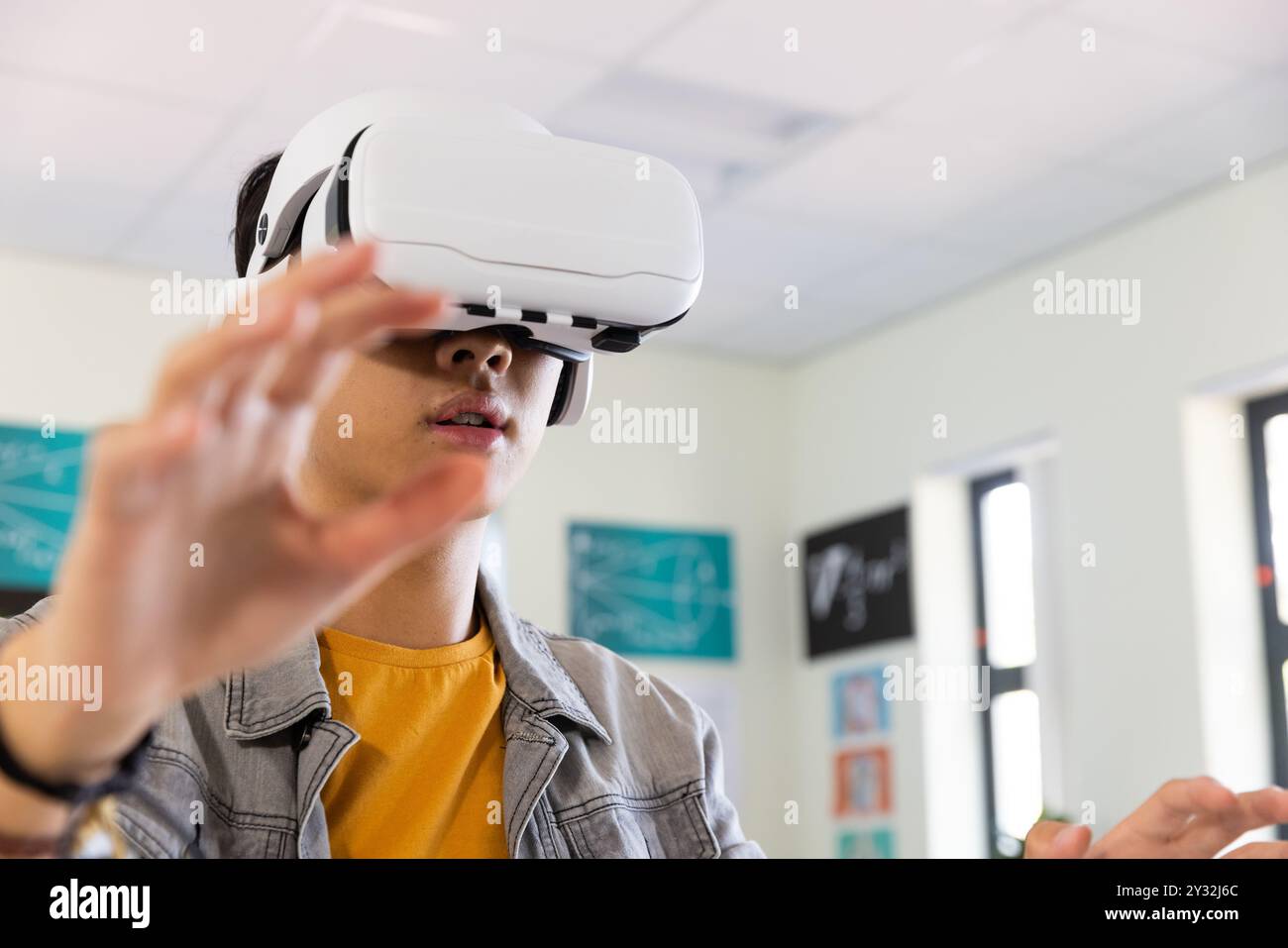 Using VR headset, asian teenage boy exploring virtual reality in school ...