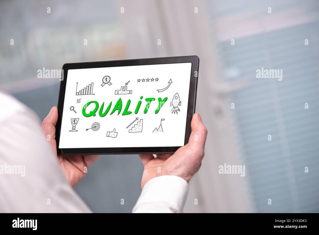 Quality concept shown on a tablet held by a man Stock Photo