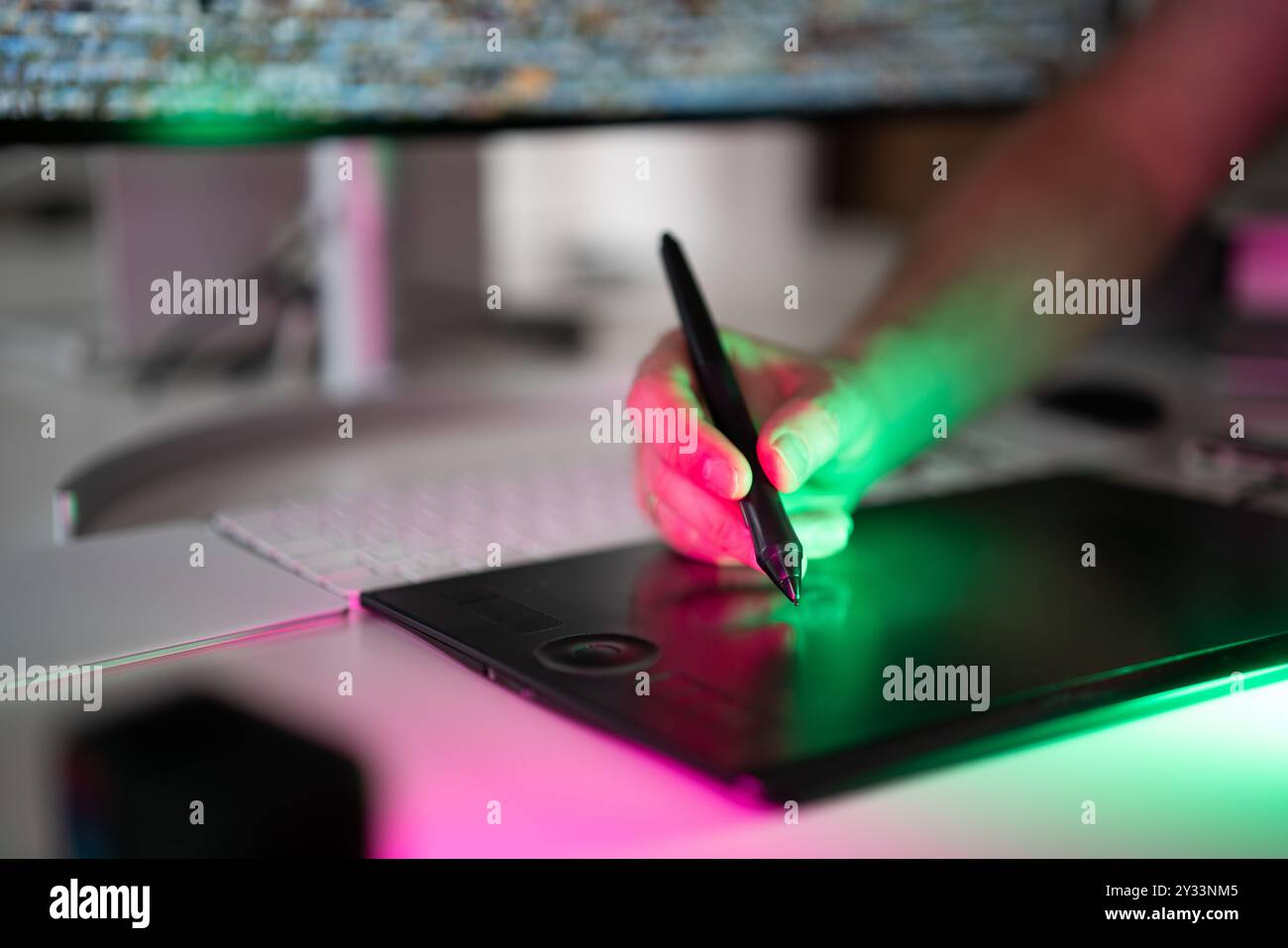 Hand holding a graphics tablet pen. Home studio interior. Photo editing ...