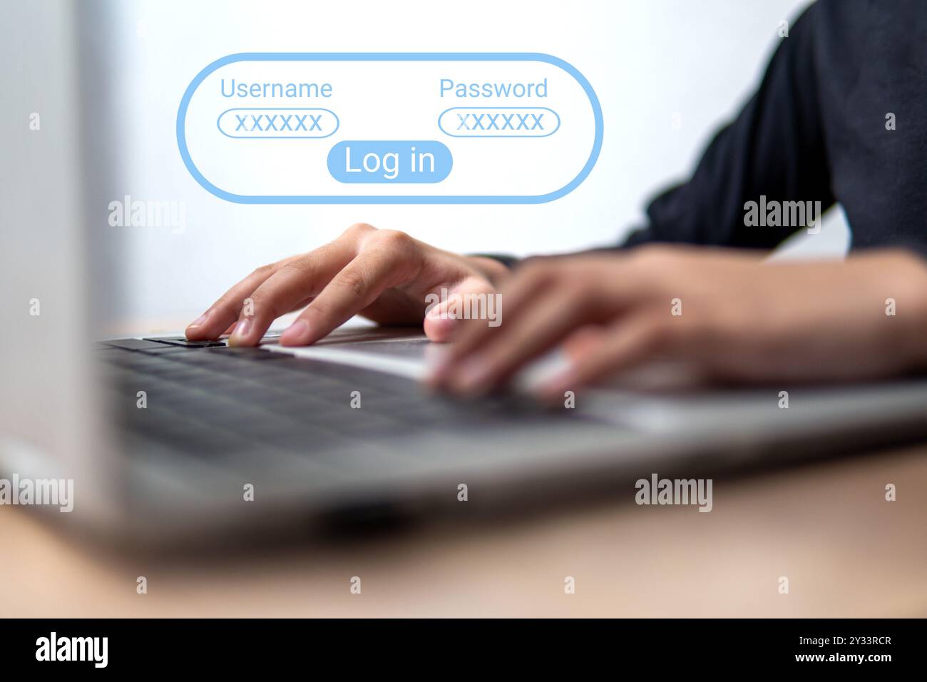 A close-up image of a person using a laptop with a login screen displayed. Privacy and security concept. Stock Photo
