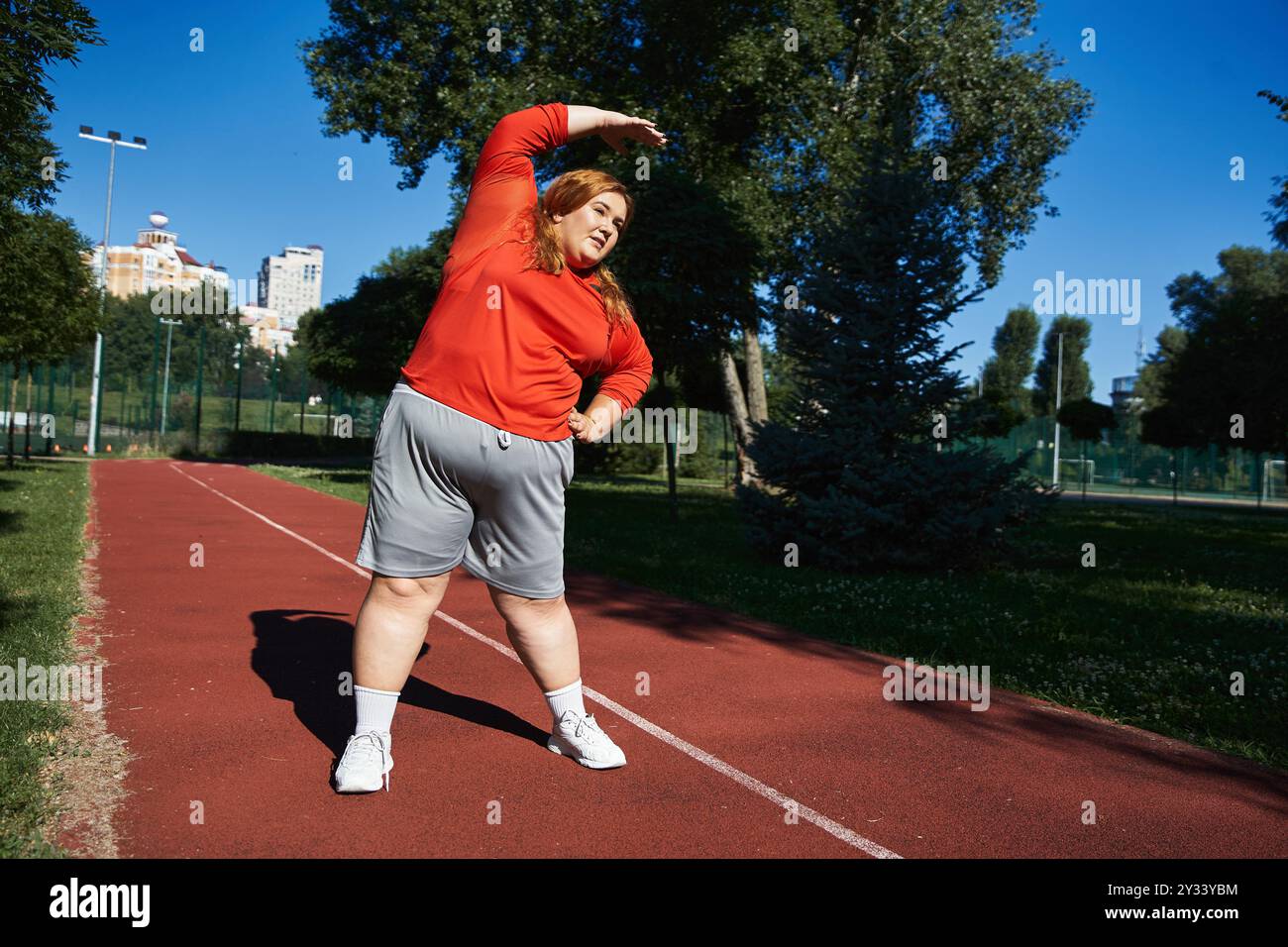 Stretch Routine For Plus Size A lively plus size woman enjoys stretching as she exercises outdoors ...