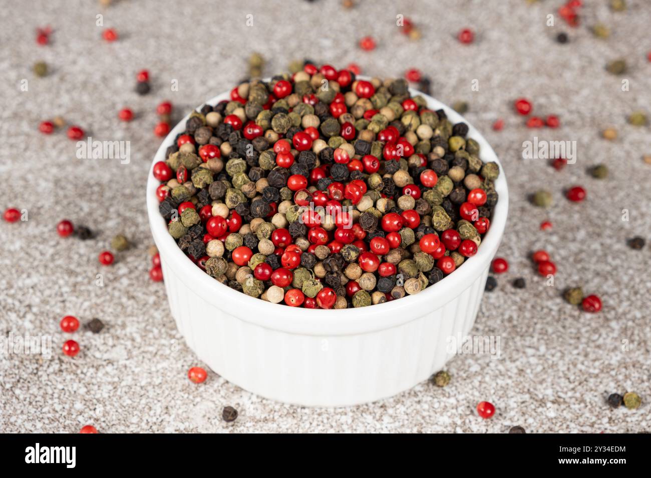 Multicolored peppercorns on a stone gray background. Stock Photo