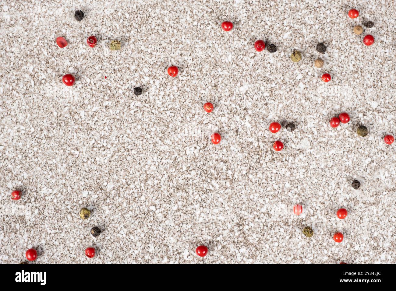 Multicolored peppercorns on a stone gray background. Stock Photo
