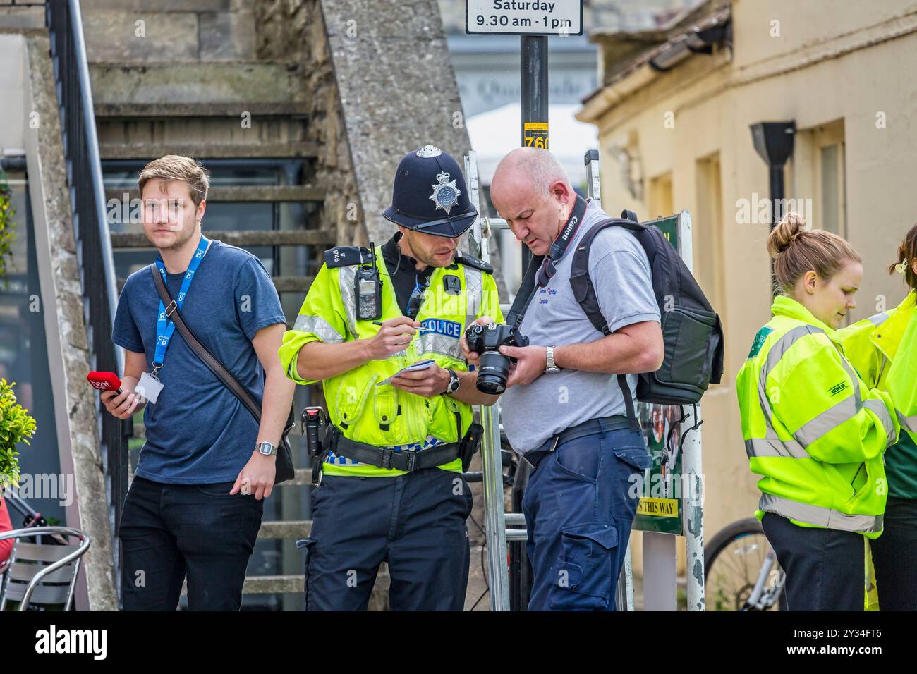 Young policeman and photographer viewing photographs together on camera screen during the Tour of Britain cycle race as it passed through Bradford on Stock Photo