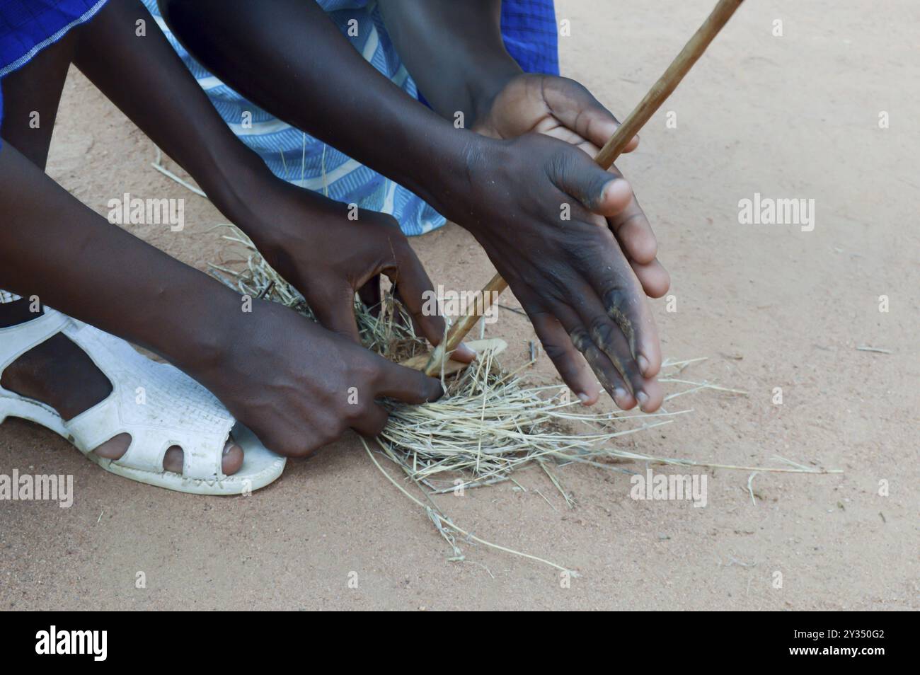 Lighting a fire with pieces of wood and straw by Masais Stock Photo - Alamy