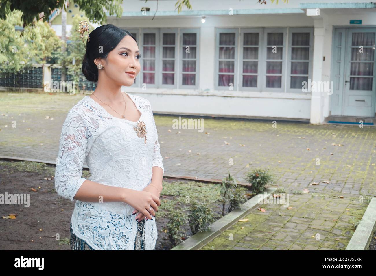 A young Indonesian woman with a happy successful expression wearing a white kebaya. Kartini's Day Concept. Stock Photo