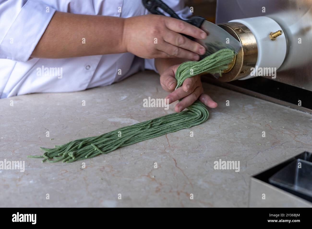 Chef Prepares Green Noodles Using A Pasta Machine In A Trendy Kitchen Chef prepares green noodles using a pasta machine in a trendy kitchen