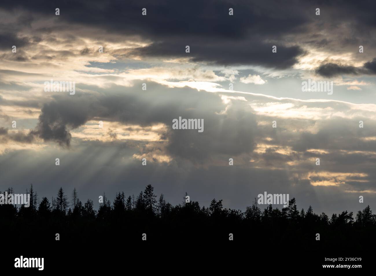 A dramatic sky with dark clouds and rays of sunlight breaking through ...