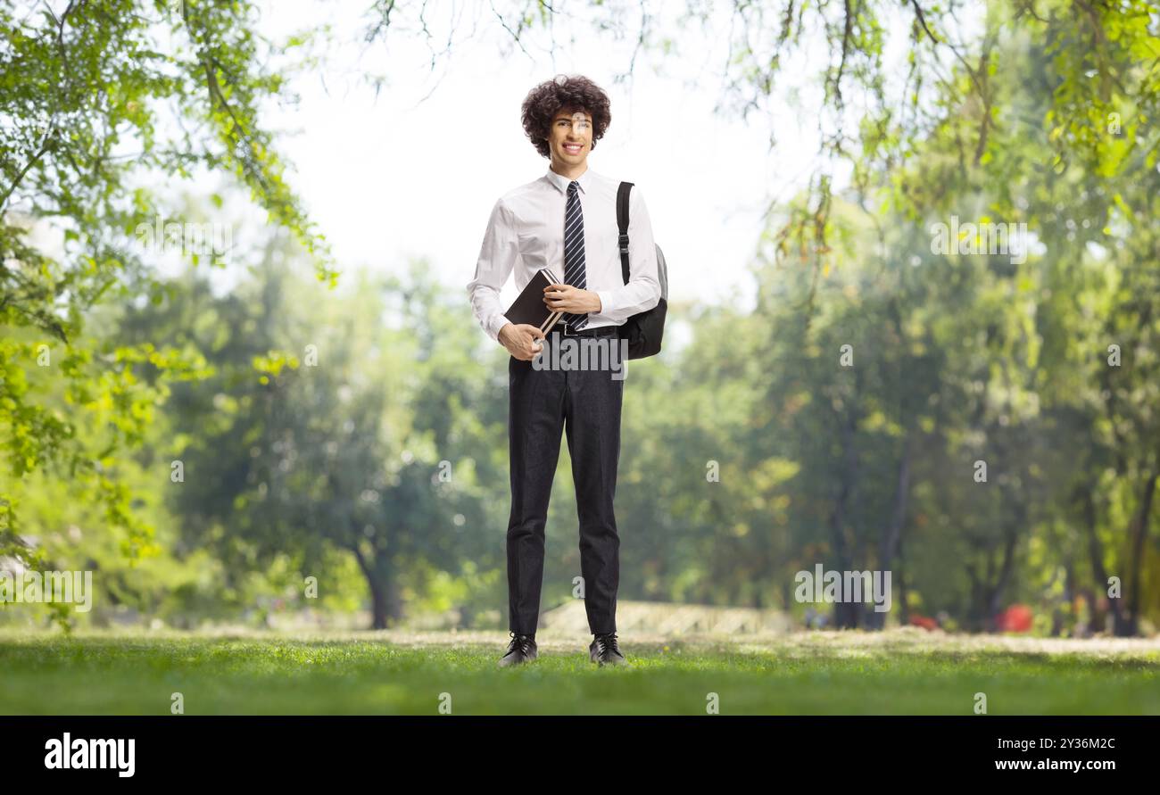 College student with books standing in a park Stock Photo - Alamy