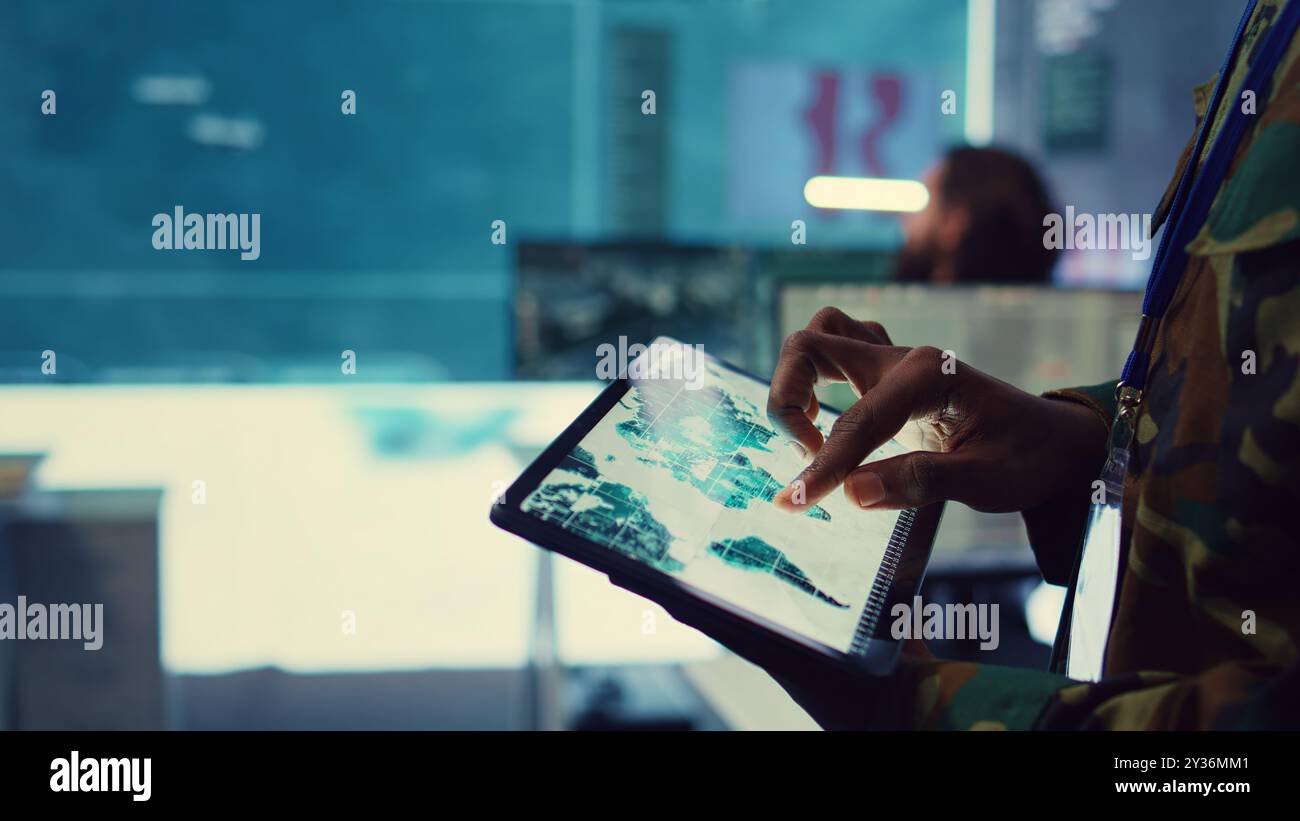 Army officer examines reconnaissance system on a world map, targeting ...