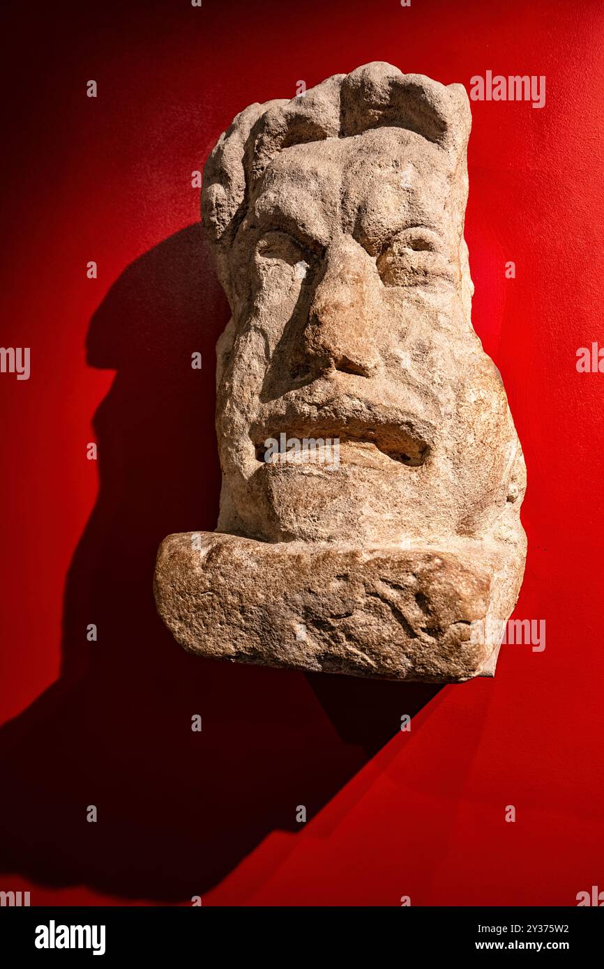Bath, England - 05-29-2024: Theatrical mask sculpted in local Bath stone, probably from a large tomb in Bath England. The deceased may have had a conn Stock Photo