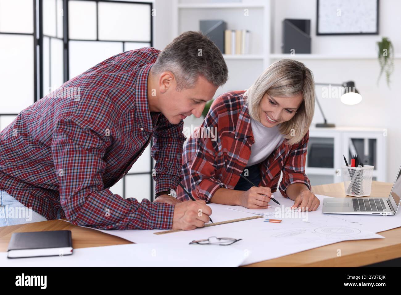 Architects making engineering drawing at wooden table in office Stock Photo