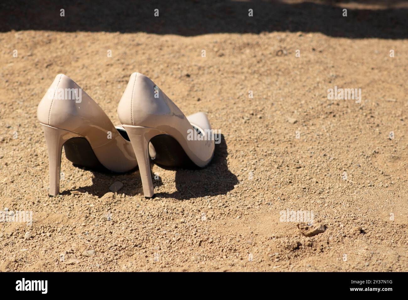 pair of beige heels sitting on baseball field dirt Stock Photo