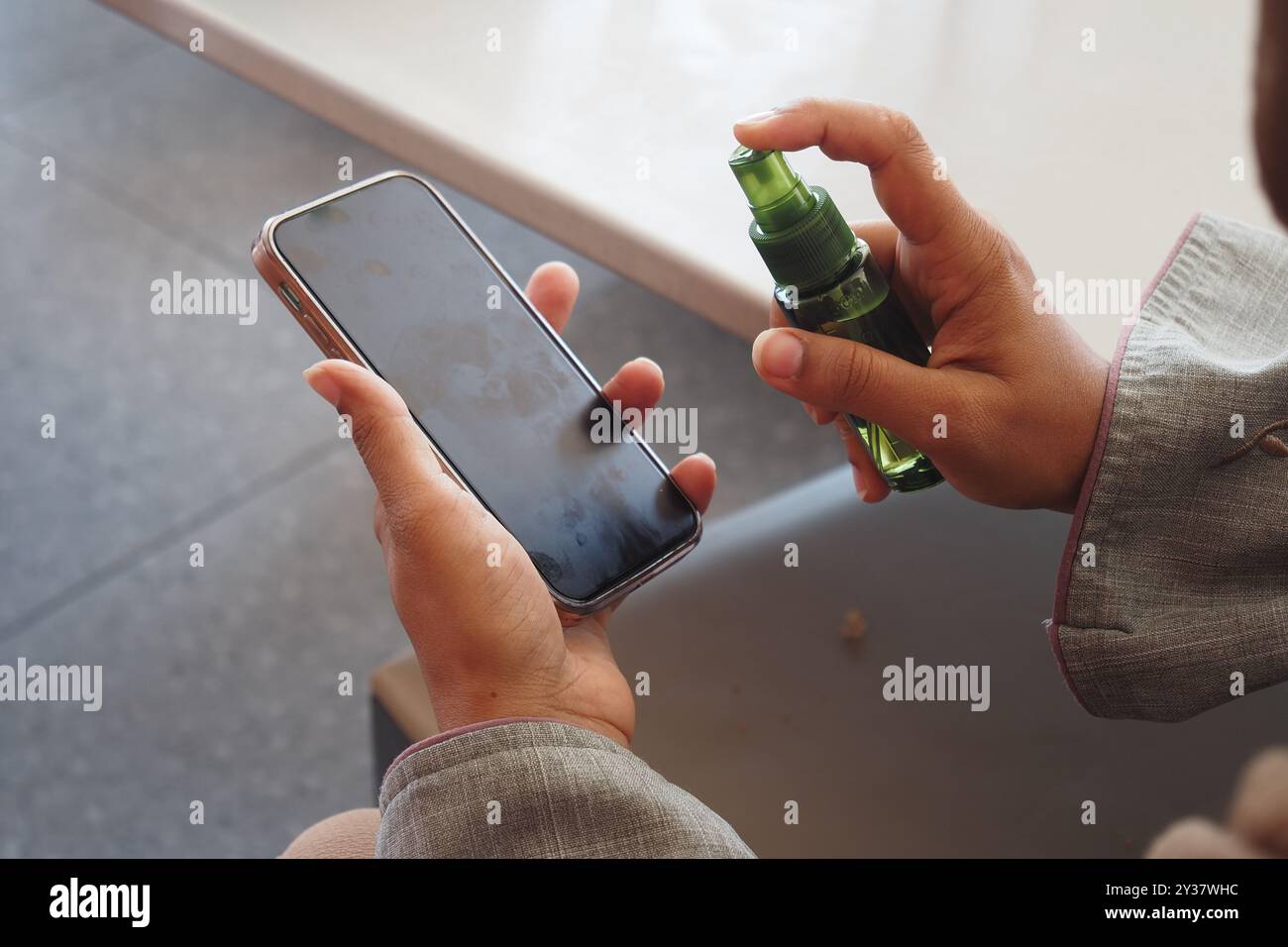 cleaning mobile phone display with sanitizer liquid Stock Photo - Alamy