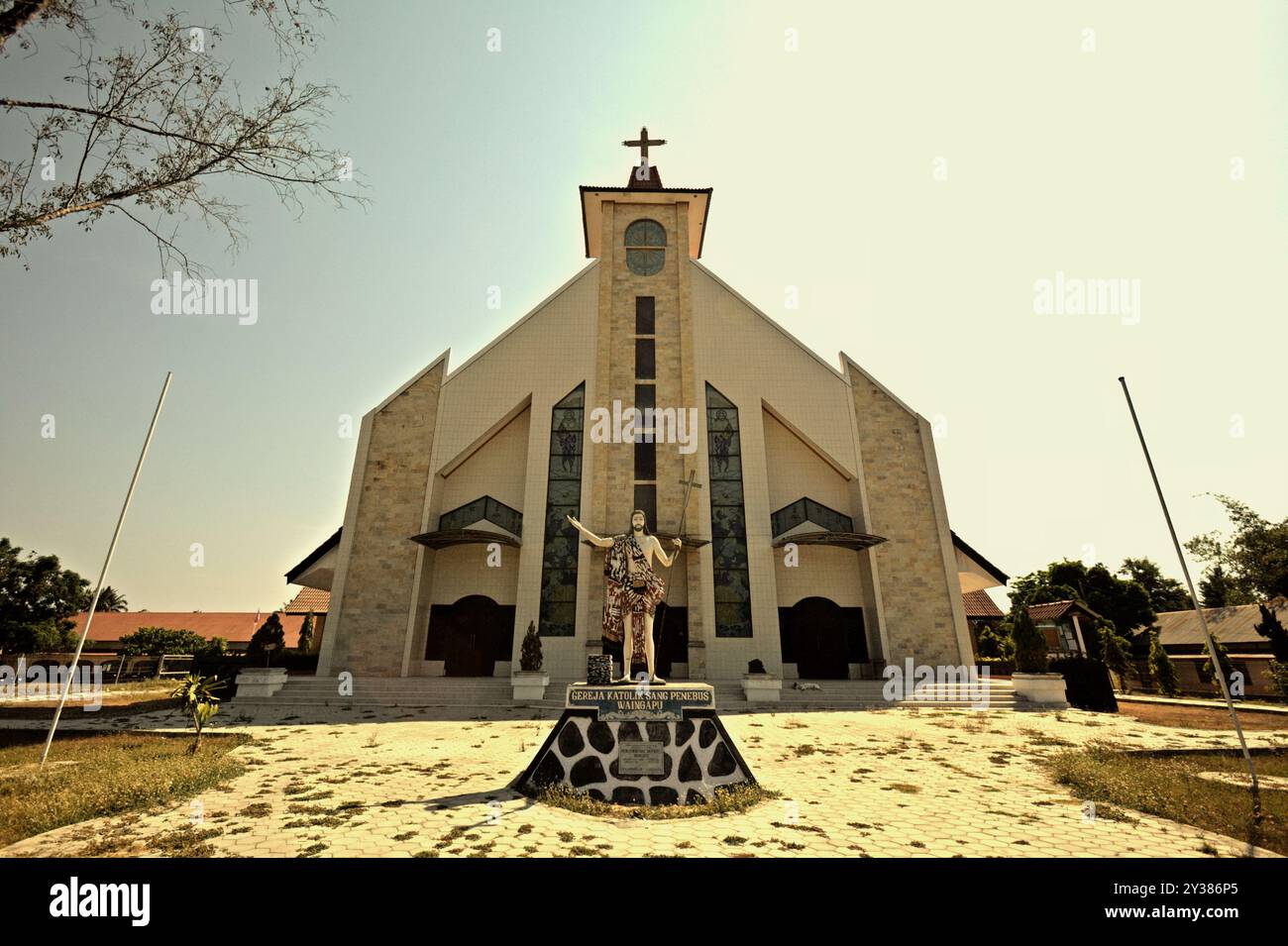 Gereja Katolik Sang Penebus (Catholic Church of The Redeemer) with statue of Jesus holding a cross and wearing Sumbanese textile in Waingapu. Stock Photo