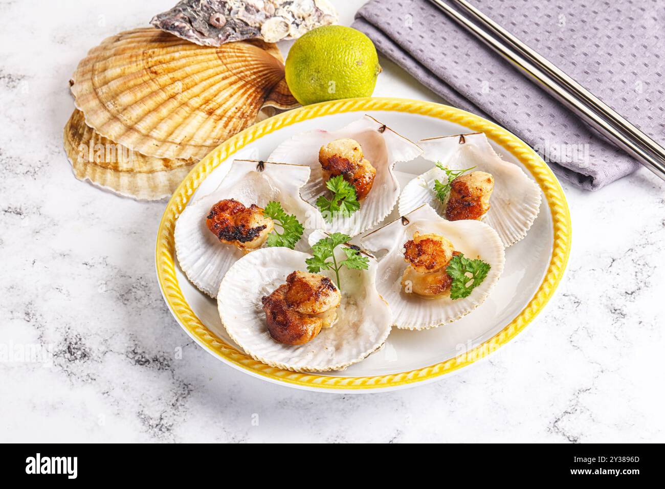 Scallops With Shell Grilled scallops shell with butter and parsley Stock Photo - Alamy