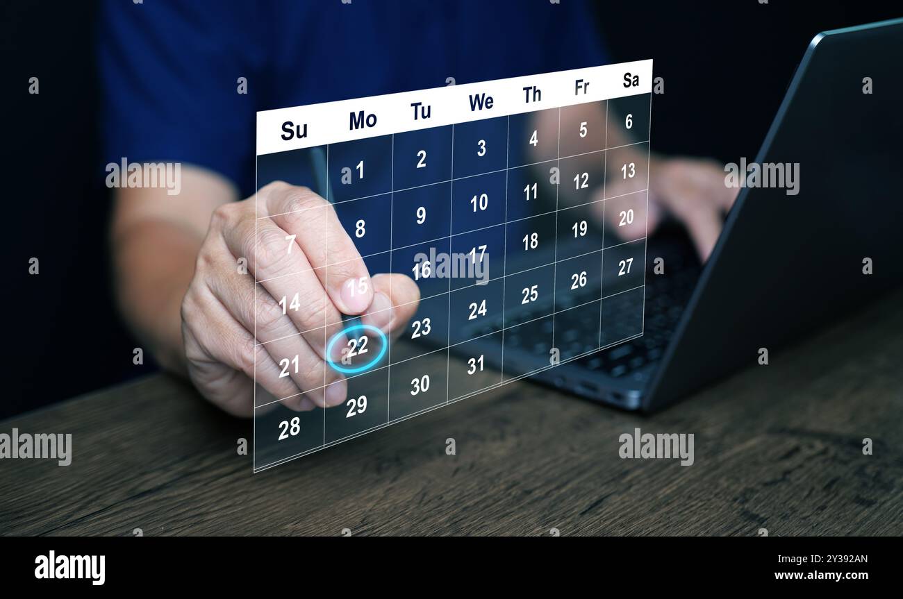 Planning and time management concept. A man manages his time using calendar on virtual screen interface, using his stylus to highlight the date to rem Stock Photo