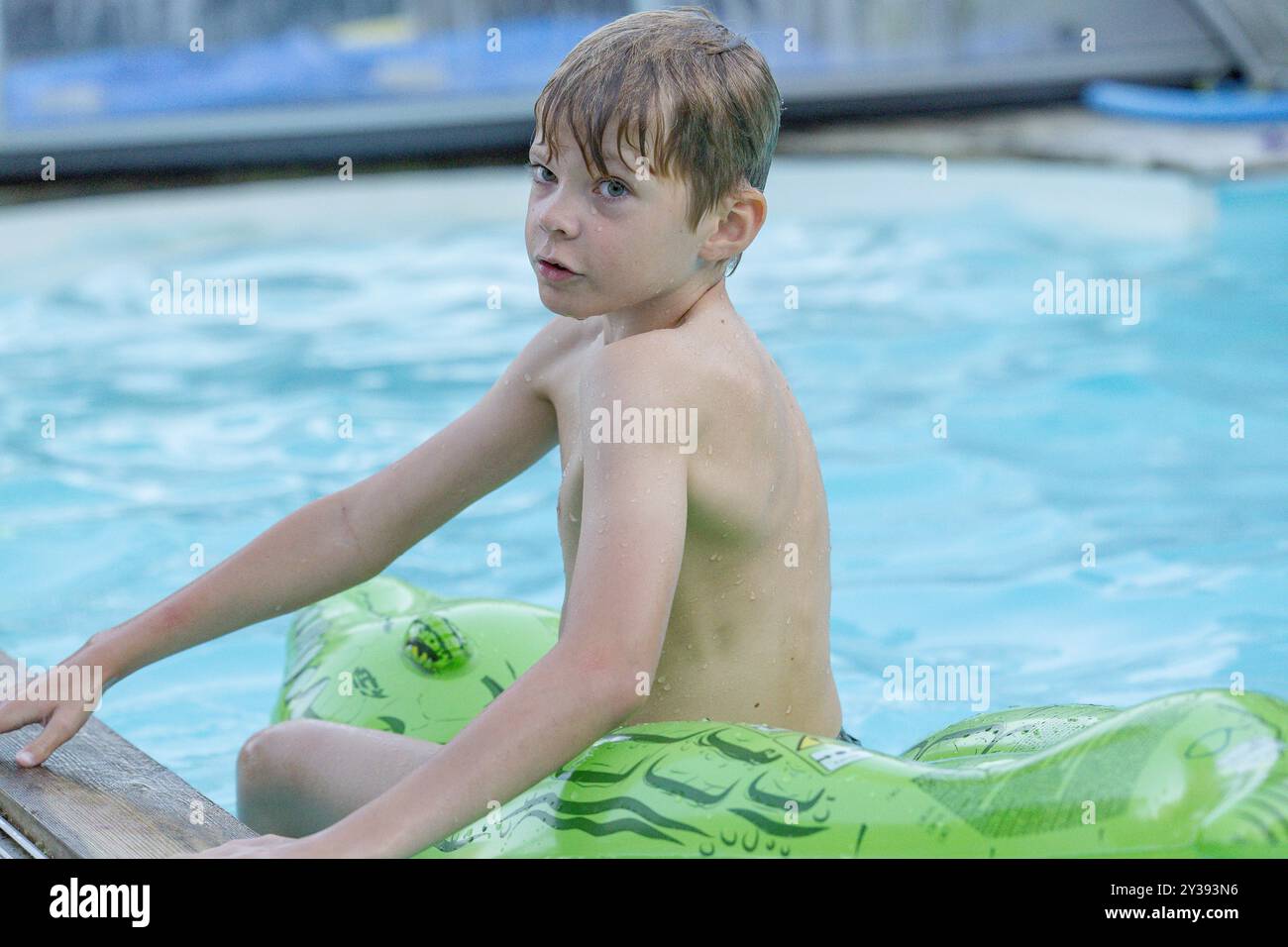 Young boy sitting on edge of pool hi-res stock photography and images ...