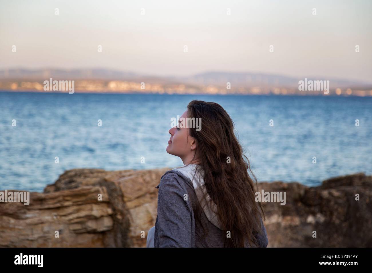 profile of beautiful woman with long hair on the beach at sunset Stock Photo