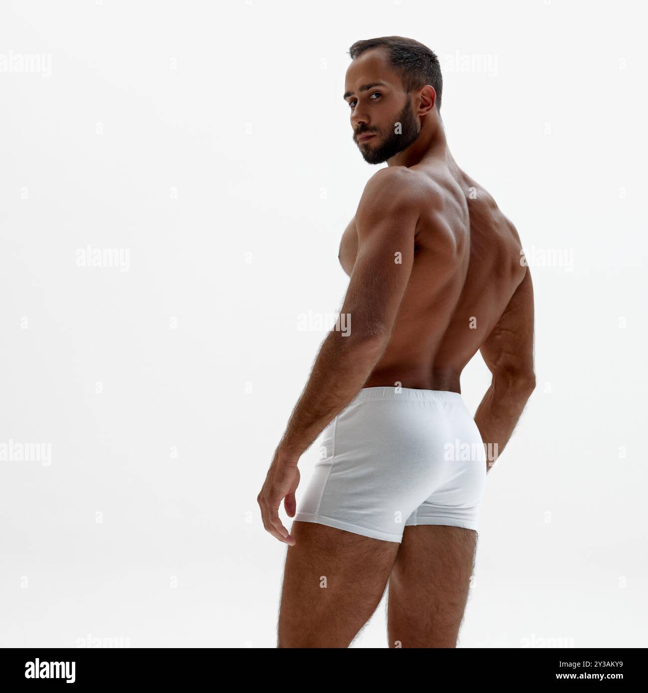 Young man turns slightly, giving view of his broad back and firm ...