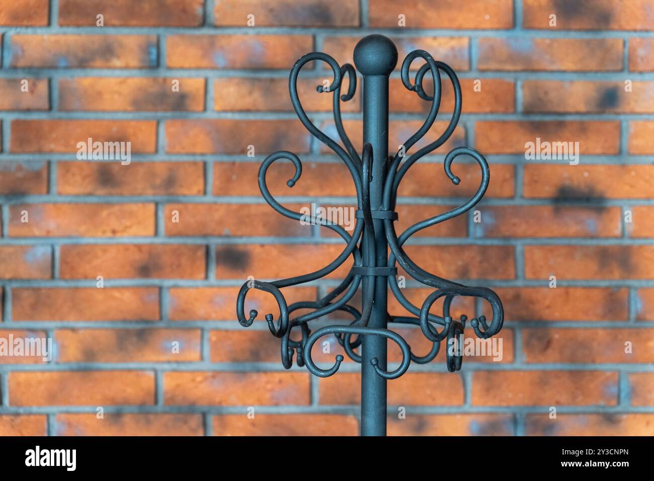 Forged Metal Stand Hanger: The Octopus Against the Brick Wall. Stock Photo