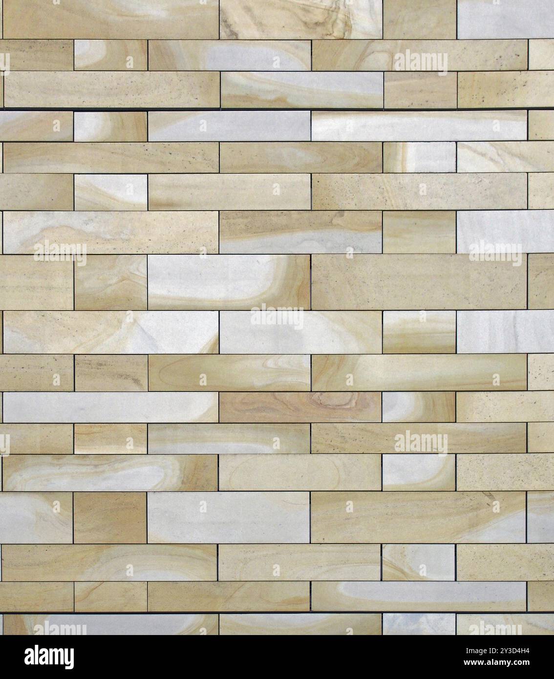 A full frame image of a wall made of large flat blocks of yellow and grey york stone with a marbled texture Stock Photo