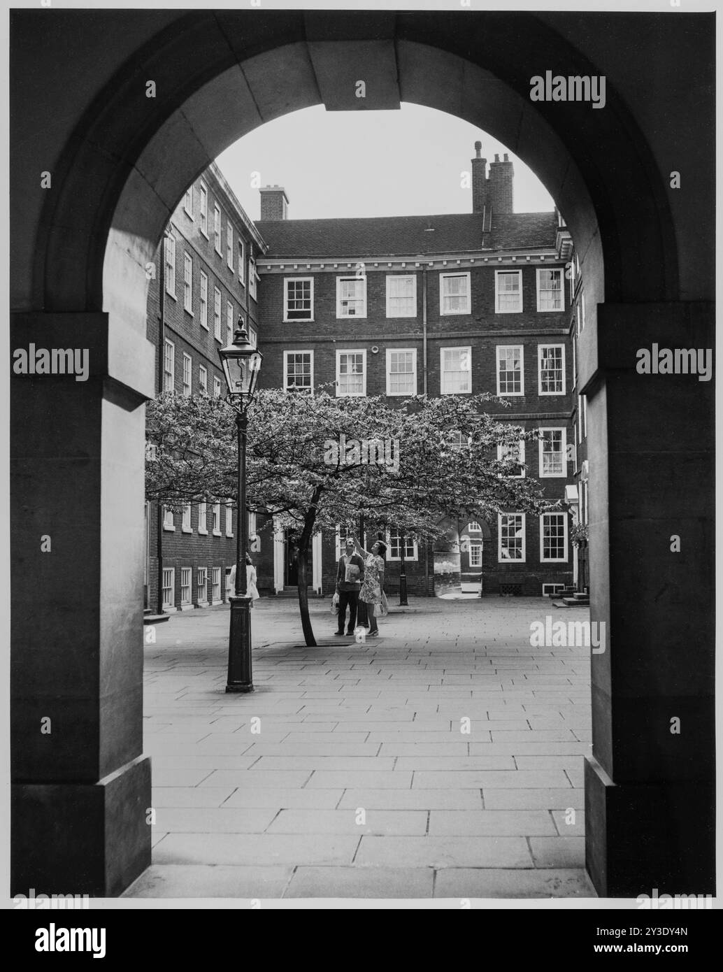 Pump Court, Temple, City of London, Greater London Authority, 1960-1985. A couple beneath the tree in Pump Court, seen from the cloisters between Pump Court and Church Court to the east. Stock Photo