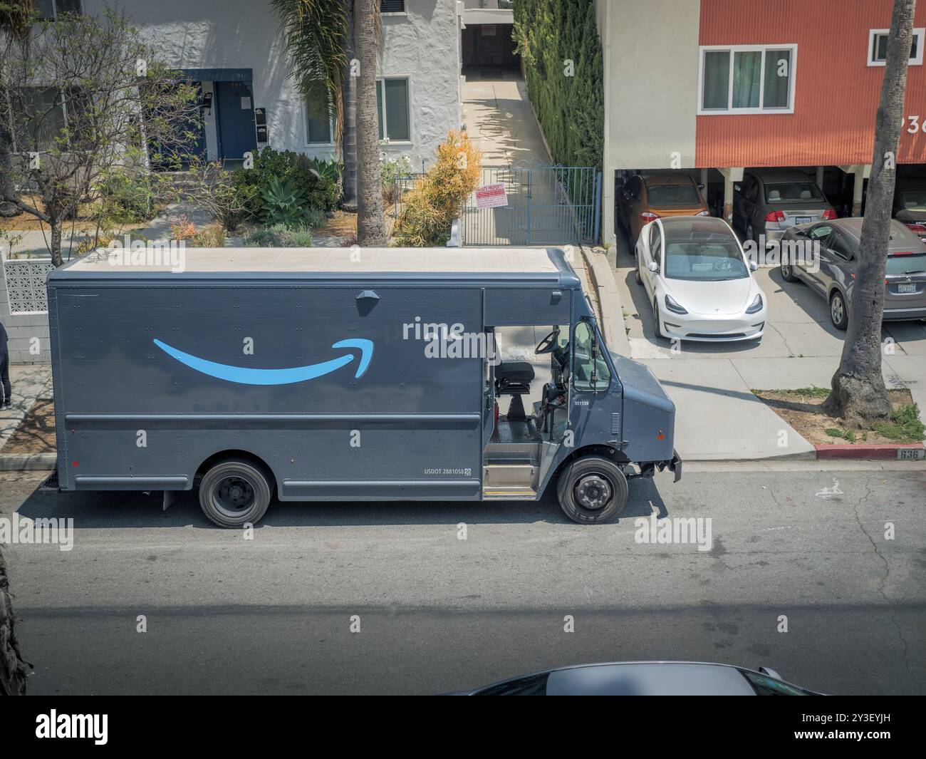 LOS ANGELES, CA - May 14 2024: Amazon Prime delivery truck delivering packages to a building on a residential street in city of West Hollywood, Califo Stock Photo