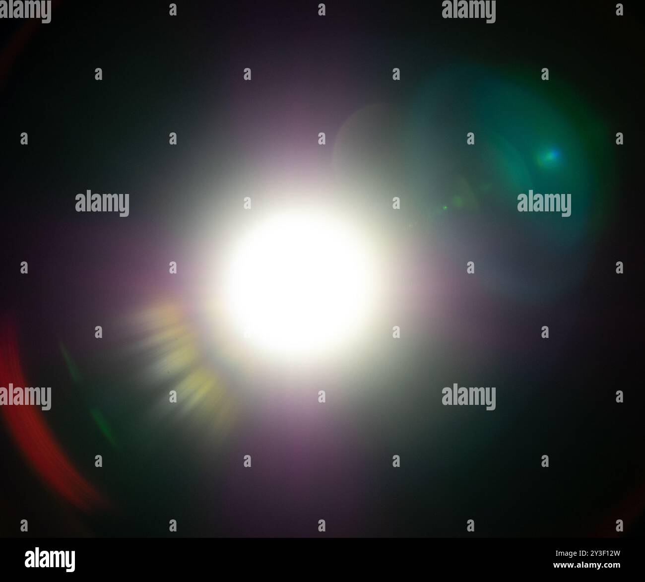 Beautiful lens flares overlay with rays and halos on black background Stock Photo