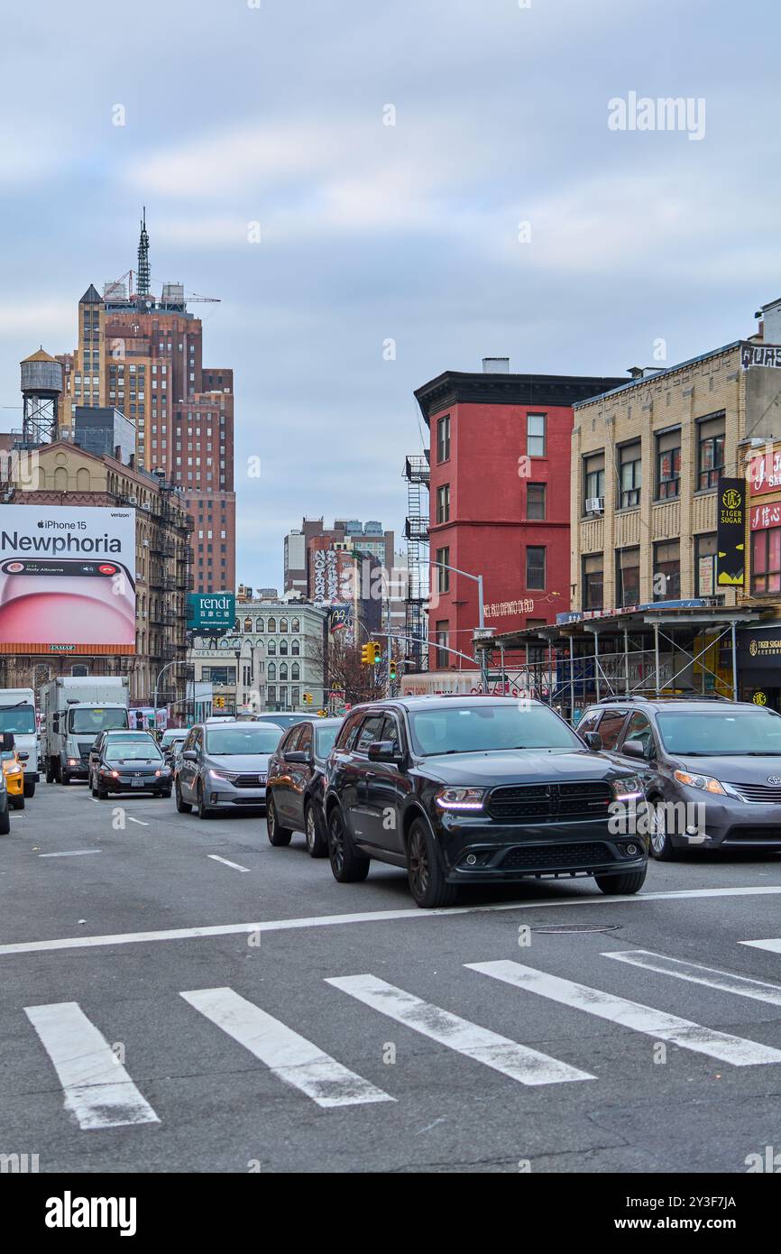 New York, United States -September 13,2024: This image captures a busy street in Chinatown, New York, featuring multiple vehicles and a prominent blac Stock Photo