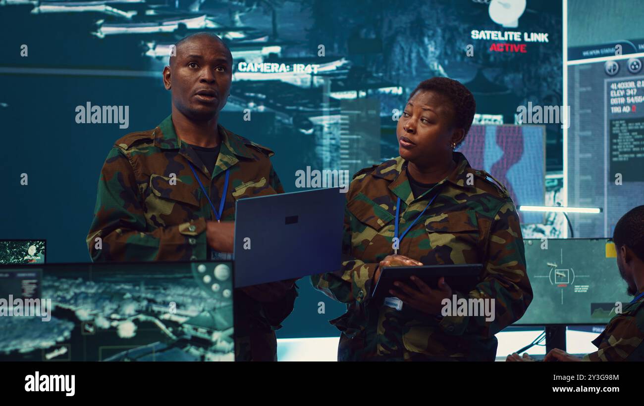 Sergeant major and female soldier checking real time field data in ...