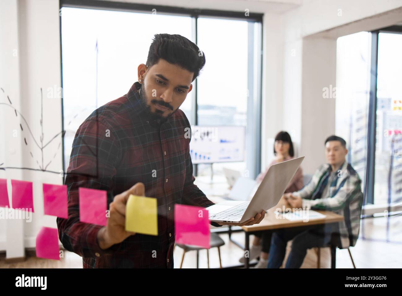 Team brainstorming session with sticky notes and laptop Stock Photo - Alamy