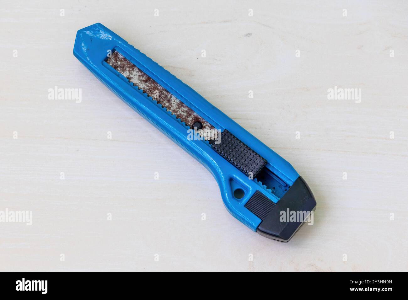 Rusty old cutter on a light wooden surface. Stock Photo