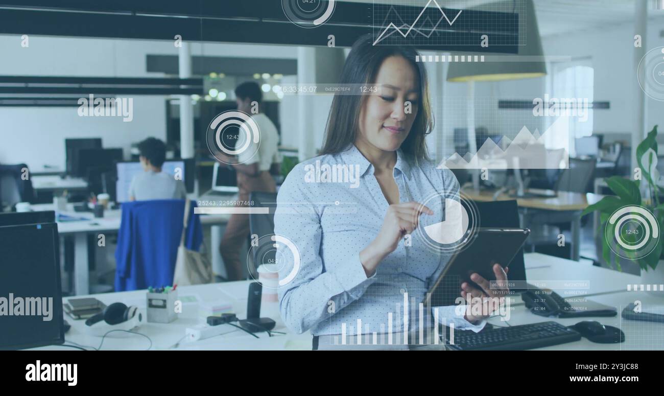 Image of financial data processing over biracial businesswoman using tablet in office Stock Photo